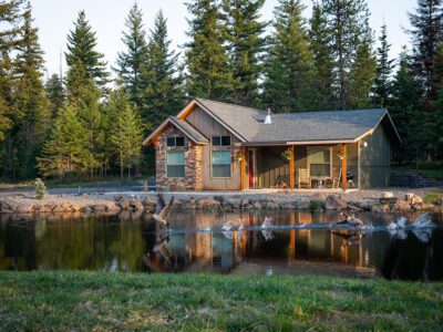 A lakeside cabin surrounded by woods.