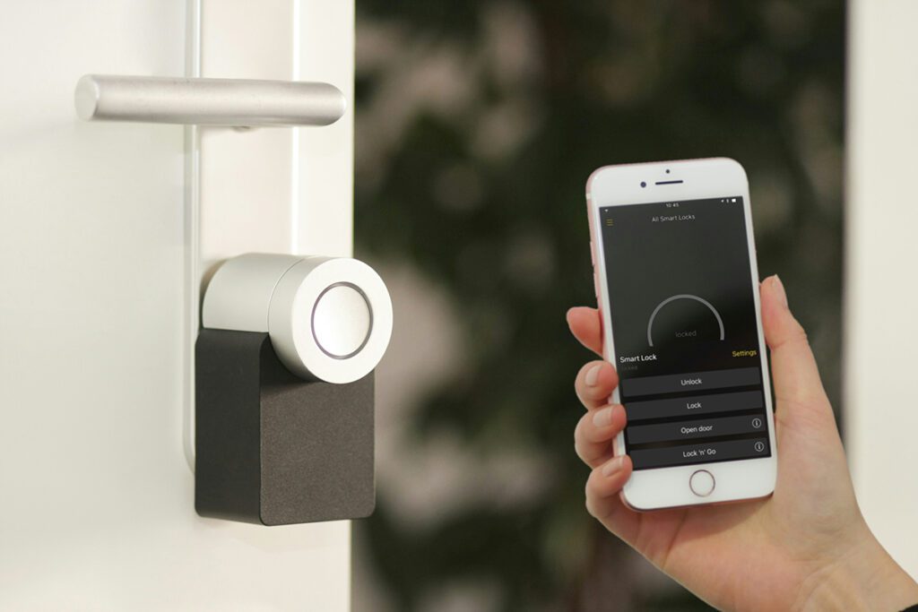 Smart home keyless entry with a phone being held up showing smart lock activated.