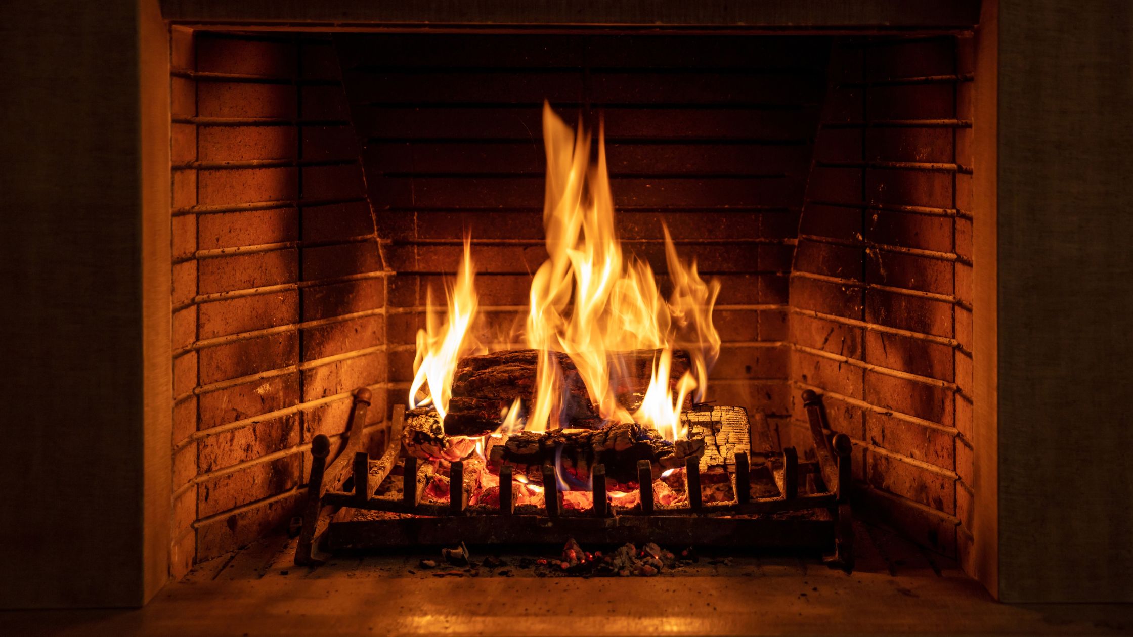 Wood burning fireplace with open face and iron log rack.