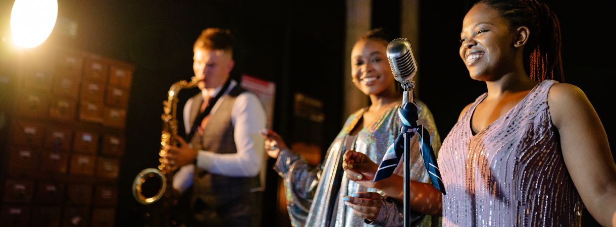 Jazz band, man playing a saxophone, accompanying two female singers